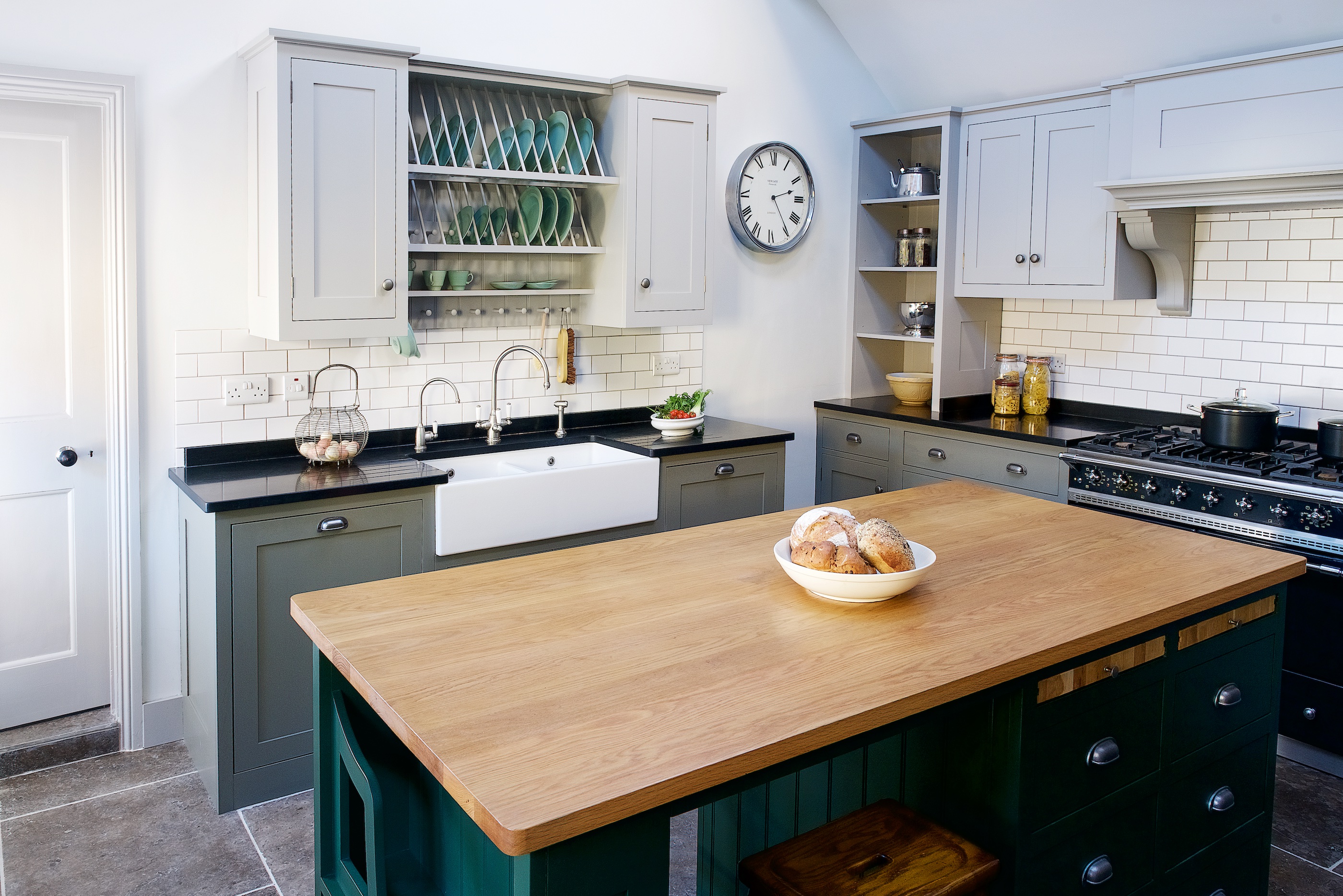 Bespoke shaker kitchen handpainted in Little Greene with a large island with oak worktop and white metro tile splashaback.