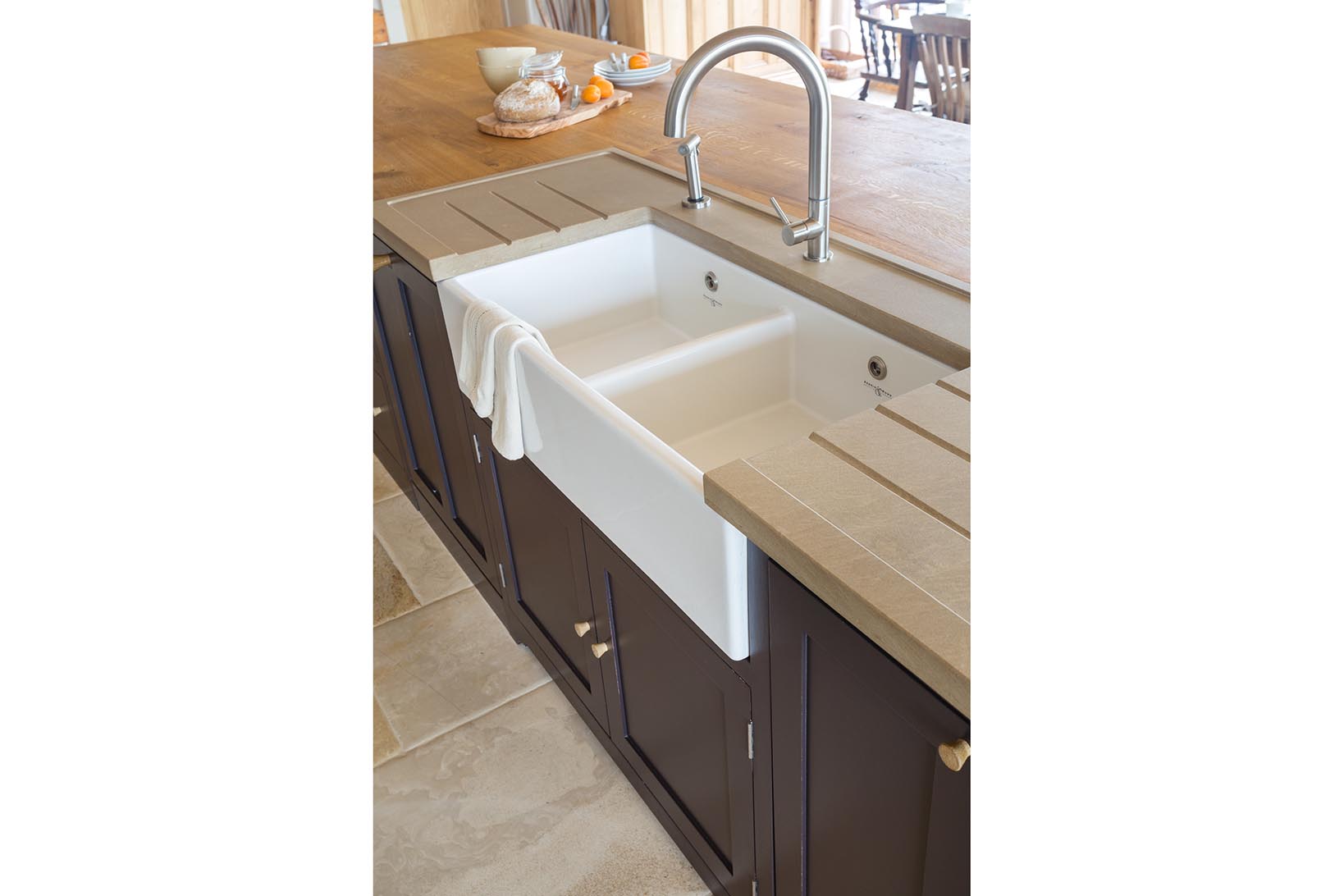 Moleanos limestone sink insert with drainers with Perrin & Rowe Shaker 900 sink and Adobe taps in stainless steel on island.