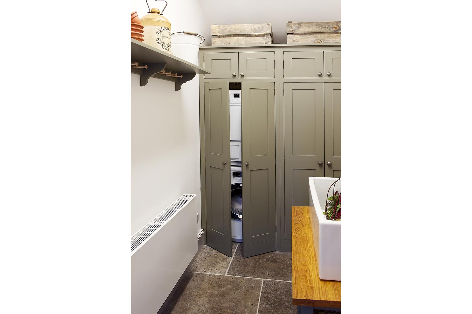 Bespoke handmade shaker utility cabinet for stacked Miele washing machine and tumble dryer with pewter handles.