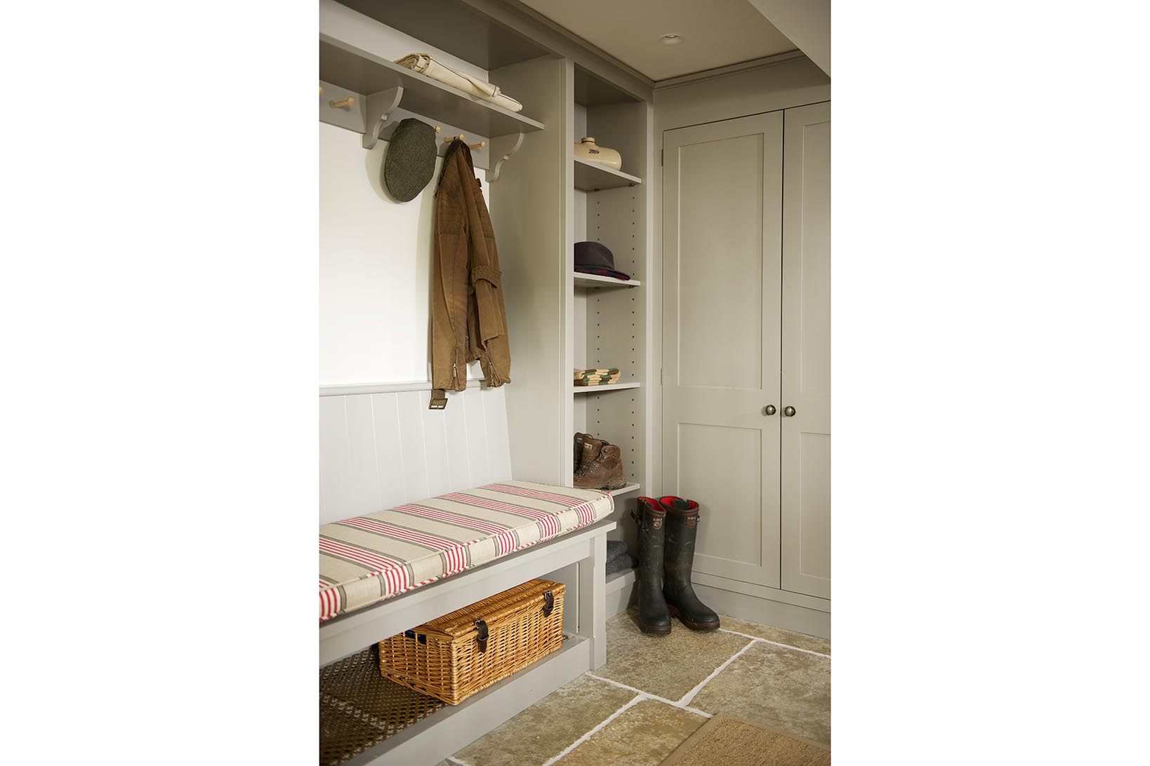 Bespoke handmade boot room with open shelves and shaker pegs on a bracketed shelf and a bench all hand painted in grey.