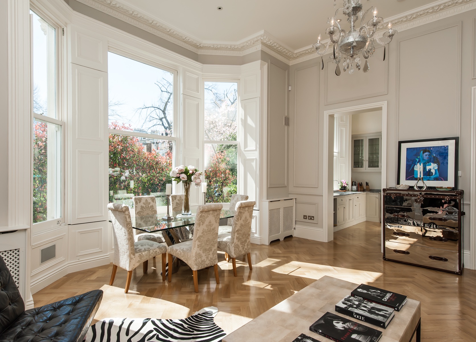 High ceiling dining living room with bay windows and wall panelling looking into the bespoke CK shaker grey kitchen