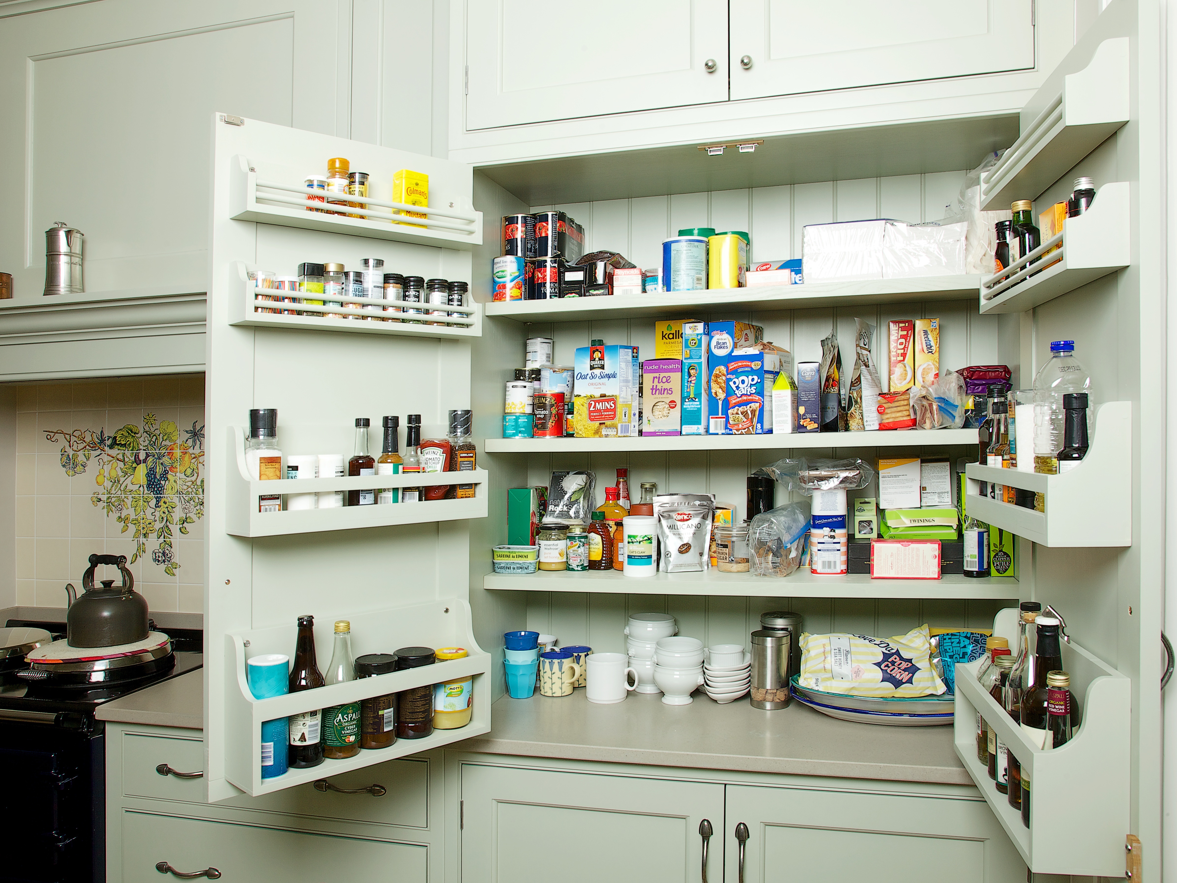 Open Charlie Kingham bespoke shaker style larder painted in Mizzle with door racks and pewter finish handles.